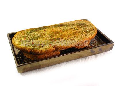 Pan tostado aromatizado con ajo, hierbas y aceite de oliva